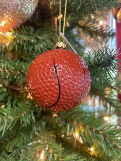 a red ornament hanging from a christmas tree