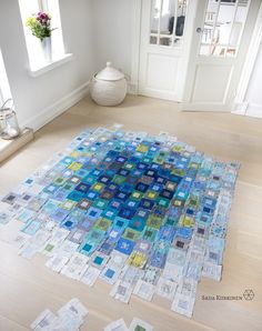 a blue and green area rug sitting on top of a hard wood floor next to a window