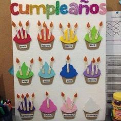 cupcakes with candles are displayed on a bulletin board