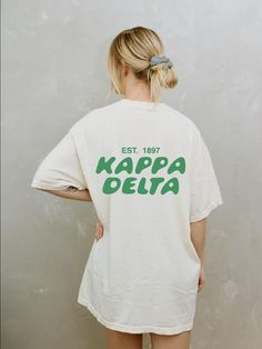 Soft, cute, and trendy, this Kappa Delta sorority t-shirt will quickly become your go-to cozy shirt! Use the drop down to specify preference between white, ivory, chambray, orchid, or blossom. LISTING IS FOR KAYDEE. Please be sure you are ordering for your correct Sorority. We print on high quality, soft, & heavyweight materials, sustainably made and printed in the US. ♥ SIZING ♥ Unisex Sizing- For a more feminine, fitted look we recommend getting your size. For a more oversized look, we recomme Kappa Delta Shirt, White School Spirit T-shirt For Everyday, Oversized School Spirit T-shirt With Letter Print, Pre-shrunk Sorority T-shirt With Crew Neck, White Crew Neck Sorority T-shirt, White Short Sleeve Sorority Top, White Sorority Graphic Print T-shirt, Sorority Cotton T-shirt With Graphic Print, Sorority Style Cotton T-shirt With Text Print