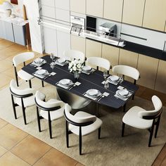 a dining room table with white chairs and plates on it in front of an oven