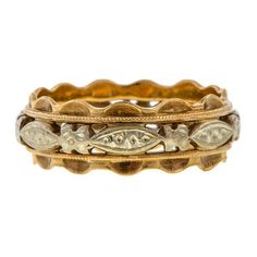 an antique gold and silver ring with fish on the inside, set against a white background