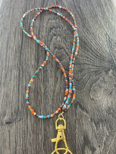 "I call this color combination of beads \"Turquoise Harvest\". This beautiful lanyard is made with hand selected glass seed beads. It is very lightweight and comfortable to wear. We do custom designs also! Lanyards can be used to hold work or school ID badges, eyeglasses or sunglasses, keys, flash drives, life alert sensors, or whatever else you wish! They make wonderful gifts for teachers, hospital workers, and corporate employees. Available in 2 sizes: 34\" or 37\". Picture shown on model (5'7 Fall Teacher Lanyard, Glass Bead Keychain, Colorful Beads Lariat Necklace For Beach, Turquoise Lariat Beaded Necklace With Colorful Beads, Multicolor Lariat Beaded Necklaces For Beach, Multicolor Lariat Beaded Necklace For Beach, Multicolor Bohemian Beaded Necklace, Bohemian Beaded Necklace With Lobster Clasp, Turquoise Lariat Beaded Necklace