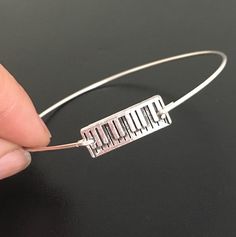 "Piano Bracelet - Keyboard Jewelry - Piano Player Gift A silver tone piano charm has been transformed into a piano bangle bracelet with bangle band choice of silver filled or sterling silver. The perfect gift for piano player or piano teacher gift. This piano bracelet stacks great with other bangles from my collection. Have fun stacking your piano jewelry for the ultimate layered look; http://www.etsy.com/shop/frostedwillow Personalize your piano bracelet with custom initial charms to create a c Piano Bracelet, Musical Bracelet, Piano Jewelry, Piano Teacher Gift, Teacher Gift Christmas, Piano Gifts, Christmas Piano, Music Teacher Gift, Metal Smithing