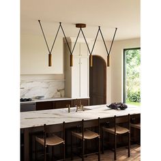 a kitchen with marble counter tops and bar stools in front of an open window