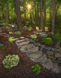 two wooden chairs sitting in the middle of a forest filled with trees and rocks, surrounded by greenery