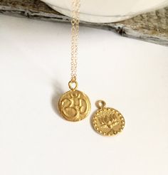 "Beautiful Gold Coin Om and Lotus Flower Charm Necklace The lotus flowers mean purity of speech, mind and body rising above the waters of desire and attachment. Lotus tattoos are meant to represent life, new beginnings and the possibility of people growing to change into something beautiful. Thus Om mystically embodies the essence of the entire universe. This meaning is further deepened by the Indian philosophical belief that God first created sound and the universe arose from it. As the most sa Spiritual Medallion Necklace With Coin Pendant, Spiritual Coin Pendant Necklace, Spiritual Round Pendant Necklace For Meditation, Spiritual Round Pendant Coin Necklace For Meditation, Spiritual Medallion Pendant Necklace With Charms, Spiritual Coin Necklace With Charms As A Gift, Spiritual Sterling Silver Medallion Necklace, Handmade Spiritual Medallion Necklace, Spiritual Coin Necklace With Charms For Gift