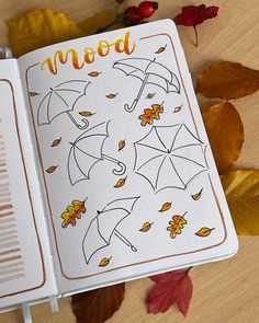 an open notebook with autumn leaves and umbrellas on it next to the word mood