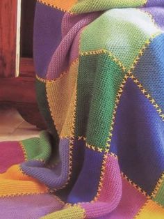 a multicolored blanket sitting on top of a wooden table