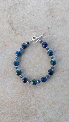 "Sterling Silver, crystal and Chrysocolla handmade beaded bracelet 7.25\".  All 2mm round beads are sterling sillver. crystals are 4mm round blue green AB.  Chrysocolla beads are 7mm faceted coin shape. Heart shape toggle clasp is pewter. Chrysocolla calms, cleanses and re-energises all the chakras. It draws out guilt, heals heartache and increases the capacity to love. Improves communication and opens psychic vision. Encourages self-awareness and inner balance. Check out my other jewelry at htt Sterling Silver Crystal Bracelet With Round Beads, Chrysocolla Gemstone Beaded Bracelets As Gift, Sterling Silver Crystal Bracelet With Spacer Beads, Faceted Turquoise Beaded Bracelets, Turquoise Faceted Beaded Bracelets, Faceted Sterling Silver Beaded Bracelets, Faceted Czech Glass Round Beads Jewelry, Adjustable Chrysocolla Gemstone Beads Bracelets, Chrysocolla Gemstone Beads Bracelet For Gift