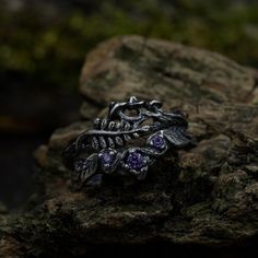 Crafted from sterling silver, our Mushroom Wedding Ring with Amethyst Chevron Twig Stack is a whimsical and enchanting elvish bridal set inspired by nature. The set includes a unique combination of rings, featuring an elven mushroom, chevron twig, and fern leaf, creating a fantasy forest aesthetic. Perfect for those embracing a witchy and dark cottagecore style, this stackable set is a unique representation of love and nature, offering a distinctive touch to your jewelry collection. Characteristics: Metal - Recycled solid sterling silver  Stone - Cubic Zirconia Finish - Oxidized. View all silver mushroom rings: https://www.etsy.com/shop/TinyShinyJewel?ref=seller-platform-mcnav&section_id=43388094 Care instructions: To care for the ring, avoid contact with water and chemicals such as perfum Silver Amethyst Crystal Ring For Wedding, Fantasy Handmade Jewelry For Promise Ring, Mystical Purple Promise Ring, Mystical Silver Rings For Weddings, Mystical Silver Rings For Wedding, Silver Magical Promise Jewelry, Mystical Purple Promise Ring Jewelry, Purple Mystical Jewelry Ring, Nature-inspired Purple Sterling Silver Jewelry