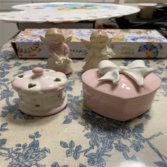 two little figurines sitting on top of a table