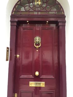 a red door with a clock above it