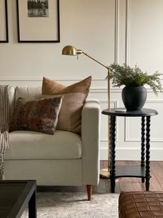 a living room with a couch, table and pictures on the wall