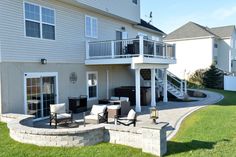 an outdoor patio with seating area and fire pit in the back yard, surrounded by grass