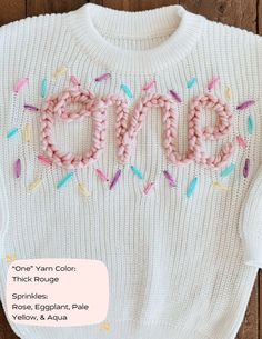 a white sweater with pink and blue sprinkles on it that says dye