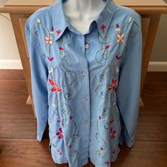 Size X Large 18 To 20 Beautiful Blue Button Down Long Sleeve Blouse . The Entire Front Is Embroidered In A Floral Design In Colors Of Red, White, Green & Purple From Top Of Shoulder To Hem 26" Underarm To Underarm When Buttoned 23" Sleeve With Button 23" 52% Cotton, 45% Polyester Slits On Sides Made In India Excellent Condition, Very Nice Fabric, Looks Brand New Smoke & Pet Free Home Blue Long Sleeve, Embroidered Blouse, Cool Fabric, White Green, Beautiful Blue, Green And Purple, Red White, Sleeve Blouse, Floral Design