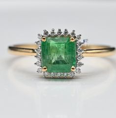 an emerald and diamond ring in yellow gold