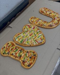 three pizzas with different toppings sitting on top of a conveyor belt