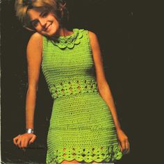 a woman in a green crochet dress posing for the camera with her hand on her hip