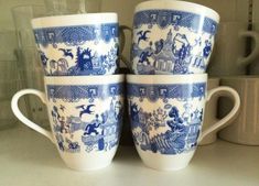 three blue and white cups sitting on top of a counter