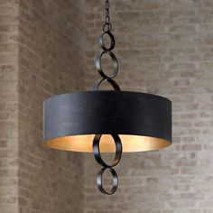 a chandelier hanging from a brick wall in a living room or dining room