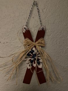 a red, white and blue bow hanging from a wall with rope attached to it