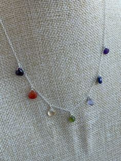 I love my crystal necklaces, I wear them every day. I have so many gemstone variations that I challenged myself to make a chakra necklace. It includes seven stones, all faceted briolettes. The stones are Garnet, carnelian, citrine, Vesuvianite, iolite, lapis lazuli and amethyst. The stones are fastened to the chain, and they sparkle with movement. The chain is solid sterling silver and so is the lobster clasp. You may specify the length. THE POPULARITY OF HEALING STONES Healing crystals are beco Silver Dangle Charm Necklace With Natural Stones, Spiritual Sterling Silver Charm Necklace With Gemstone, Sterling Silver Pendant Crystal Necklace With Gemstone Beads, Silver Charm Necklace With Natural Stones For Healing, Healing Birthstone Charm Necklaces In Sterling Silver, Healing Sterling Silver Birthstone Charm Necklace, Adjustable Faceted Crystal Necklace In Sterling Silver, Sterling Silver Healing Necklace With Gemstone Beads, Spiritual Sterling Silver Crystal Necklace With Gemstone Beads