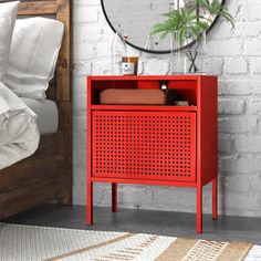 a red cabinet sitting next to a bed