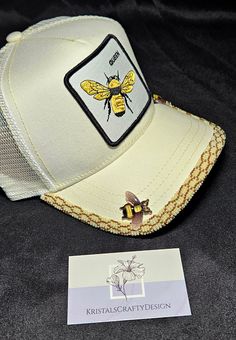 Bee*utiful beaded baseball cap brim. This hat was hand beaded in shades of lemon ice, bronze, and 2 bee cabochons. The hat is an adjustable snap back, with the top of the brim beaded. If you are interested in  custom work, please message me for details. Adjustable Gold Baseball Cap For Summer, Gold Baseball Cap For Summer, Summer Gold Trucker Hat, Adjustable Gold Trucker Hat For Summer, Gold Adjustable Trucker Hat For Summer, Handmade Gold Cap, Adjustable Gold Visor Hat, Summer Adjustable Hats With Bead Caps, Adjustable Summer Hats With Bead Caps