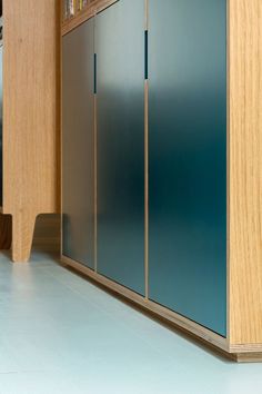 an empty room with blue glass doors on the wall and wooden cabinets in the corner