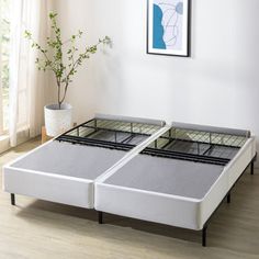 two mattresses sitting next to each other in a room with white walls and wood flooring