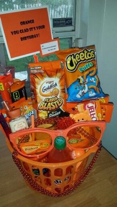 an orange basket filled with snacks and candy