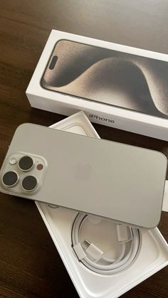 an iphone is sitting in its box on the table next to it's charger