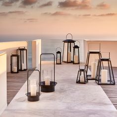 several lanterns are lined up on a deck near the ocean