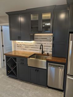 a kitchen with gray cabinets and stainless steel appliances