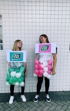 two girls are holding up boxes with balloons