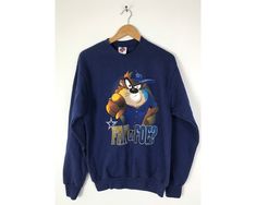 "-Description- >1995 Tasmanian Devil Dallas Cowboys fan or foe sweatshirt >crew neck pullover >size medium >perfect for a Cowboys fan! >condition: great >color(s): blue, brown, black, white >fabric(s): 50 cotton / 50 polyester >brand: league leader >care: machine wash -Measurements- >size: medium ✩ all measurements are taken with the item laying flat & some sizes are estimates so please check measurements ✩ chest: 39\" / 99cm length: 27\" / 68cm shoulder to slee Throwback Crew Neck Hoodie For Fan Merchandise, Vintage Graphic Print Sweatshirt For Fan Gear, Vintage Graphic Print Sweatshirt For Fans, Vintage Sweatshirt For Sports Season Fan Merchandise, Vintage Pre-shrunk Sweatshirt For Fan Merchandise, Vintage Pre-shrunk Sweatshirt For Fans, 90s Graphic Print Sweatshirt For Sports Season, Pre-shrunk Vintage Sweatshirt For Fans, Throwback Fan Merchandise Sweatshirt For Sports Season