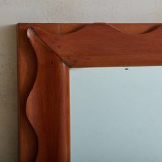 a wooden frame mirror hanging on the wall