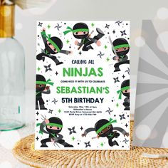 a birthday card with ninjas on it next to a glass bottle and corkscrew