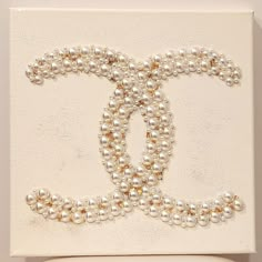 a white box with pearls on it and the letter o in the middle is decorated with beads