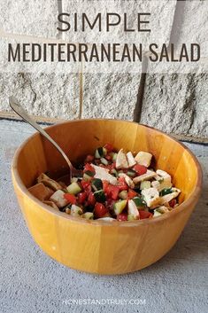 a wooden bowl filled with salad next to a stone wall and text overlay that reads simple mediterranean salad