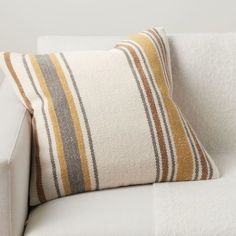 a striped pillow sitting on top of a white couch