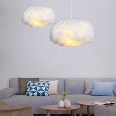 three clouds hanging from the ceiling above a couch and coffee table in a living room