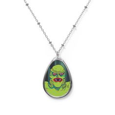 Our Creature from the Black Lagoon pendant necklace will make you or your horror-movie-loving sweetie scream with joy this Valentine's Day! The lightweight, oval shaped pendant has a white aluminum surface that features a glossy image of the Creature, while the brass chain and lobster clasp closure will keep the necklace securely in place, if ever you need to high tail it away from an actaul monster! :) Meant for fun, wear this kitschy necklace to your next outing and let your friends know that Halloween Teardrop Jewelry Gift, High Tail, Creature From The Black Lagoon, The Black Lagoon, Oval Pendant Necklace, Black Lagoon, Movie Monsters, Brass Necklace, Aluminum Prints