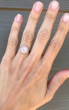 A beautiful round pink rose quartz sits in sterling silver with a handmade ring band from sterling silver half dome wire. Choose from either a simple setting or a more floral scallop setting. The rose quartz cabochon is 11mm in size. Rose quartz is a stone that promotes healing, love, and attraction. It can draw love to the the wearer, help heal from heartbreak, and help sustain feelings of love and romance. Made to order, stones vary with slight differences in color, lines, etc. Delicate Adjustable Stackable Rings, Pink Moonstone Sterling Silver Ring For Anniversary, Wire Wrapped Round Ring For Promise, Adjustable Wire Wrapped Stackable Rings, Delicate Rose Gold Sterling Silver Crystal Ring, Pink Sterling Silver Moonstone Promise Ring, Everyday Delicate Round Crystal Ring, Dainty Wire Wrapped Round Ring, Nickel-free Sterling Silver Rose Gold Rings