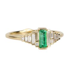 18 Karat Yellow Gold Emerald Ring (0.20 ct) with Graduated Needle Baguette Diamond Sections (0.20 tcw). Ring size 6.5. Art Deco Emerald Ring With Baguette-cut Diamond, Art Deco Emerald Ring With Baguette Diamond, Timeless Emerald Ring With Baguette Diamonds, Luxury 14k Gold Emerald Ring With Baguette Diamonds, Elegant Emerald Ring With Baguette Diamonds, Gold And Emerald Ring, Gold Ring With Diamond, Gold And Emerald, Fairy Tale Jewelry