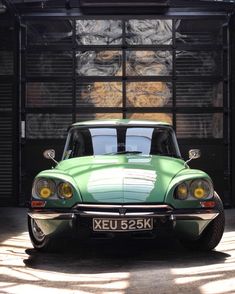 a green sports car parked in front of a building