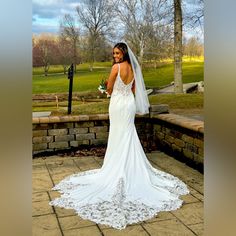 a woman in a wedding dress is posing for the camera with her back to the camera