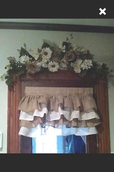 the window valance is decorated with flowers and burlocks on it's side